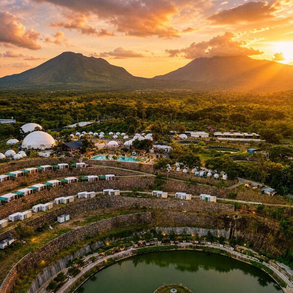 A resort with dome-shaped accommodations, a central pool, and a surrounding landscape with mountains.