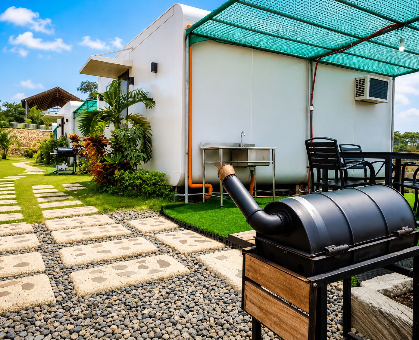 A barbecue grill, outdoor seating, and a house with a green roof.