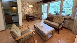 Ein gemütliches Wohnzimmer mit einer Couch, einem Couchtisch und einem Essbereich mit Tisch und Stühlen.