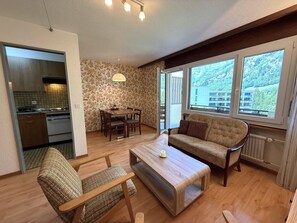 A cozy living room with a sofa, a coffee table, and a dining area with a table and chairs. - Royal 33 # 2-bed apartment, Dusche, WC 2-Bettwohnung, Dusche, WC by Interhome (Leukerbad)
