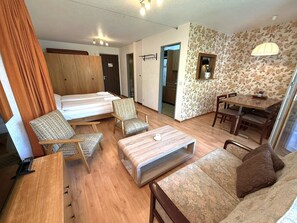 A hotel room with a bed, two chairs, a small table, a sofa, and a dining table. - Royal 33 # 2-bed apartment, Dusche, WC 2-Bettwohnung, Dusche, WC by Interhome (Leukerbad)