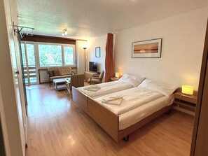 A hotel room with a large bed, a desk, a chair, and a TV. - Royal 33 # 2-bed apartment, Dusche, WC 2-Bettwohnung, Dusche, WC by Interhome (Leukerbad)