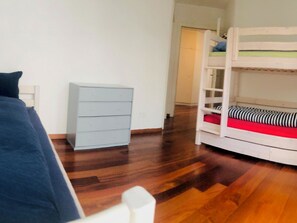 A room with a bunk bed, a dresser, and a chair. - Edelweiss B 31 # 5-bed apartment, Dusche, WC 5-bed apartment, Dusche, WC by Interhome (Leukerbad)