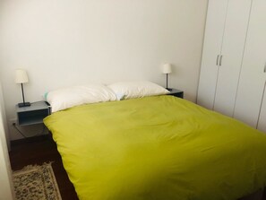 A single bed with a green bedspread, two bedside tables with lamps, and a wardrobe. - Edelweiss B 31 # 5-bed apartment, Dusche, WC 5-bed apartment, Dusche, WC by Interhome (Leukerbad)