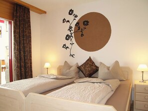 Ein Doppelbett mit zwei Kissen, ein Nachttisch mit Lampe und eine Wanddekoration.