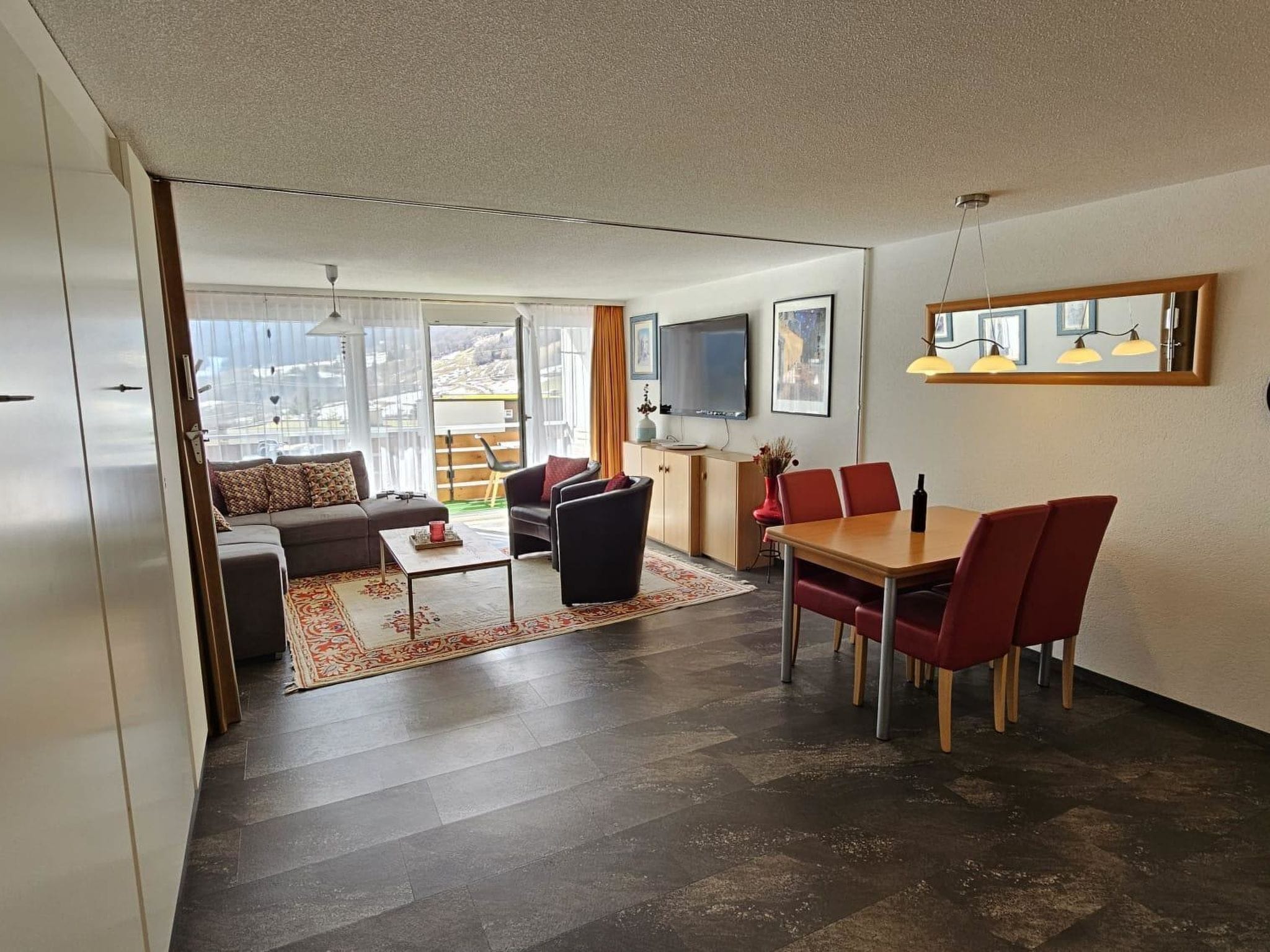 A modern living room with a sofa, coffee table, and dining area with chairs.