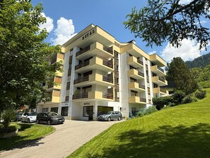Een hotel met meerdere verdiepingen, balkons, een oprit en een parkeerplaats.