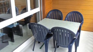 Una mesa con cuatro sillas, una partición de vidrio y una pared de madera.