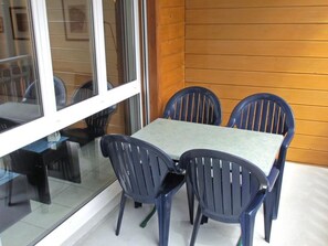 A table with four chairs, a glass partition, and a wooden wall. - Anessa 33 # 4-bed apartment, Bad, WC 4-Bettwohnung, Bad, WC by Interhome (Leukerbad)