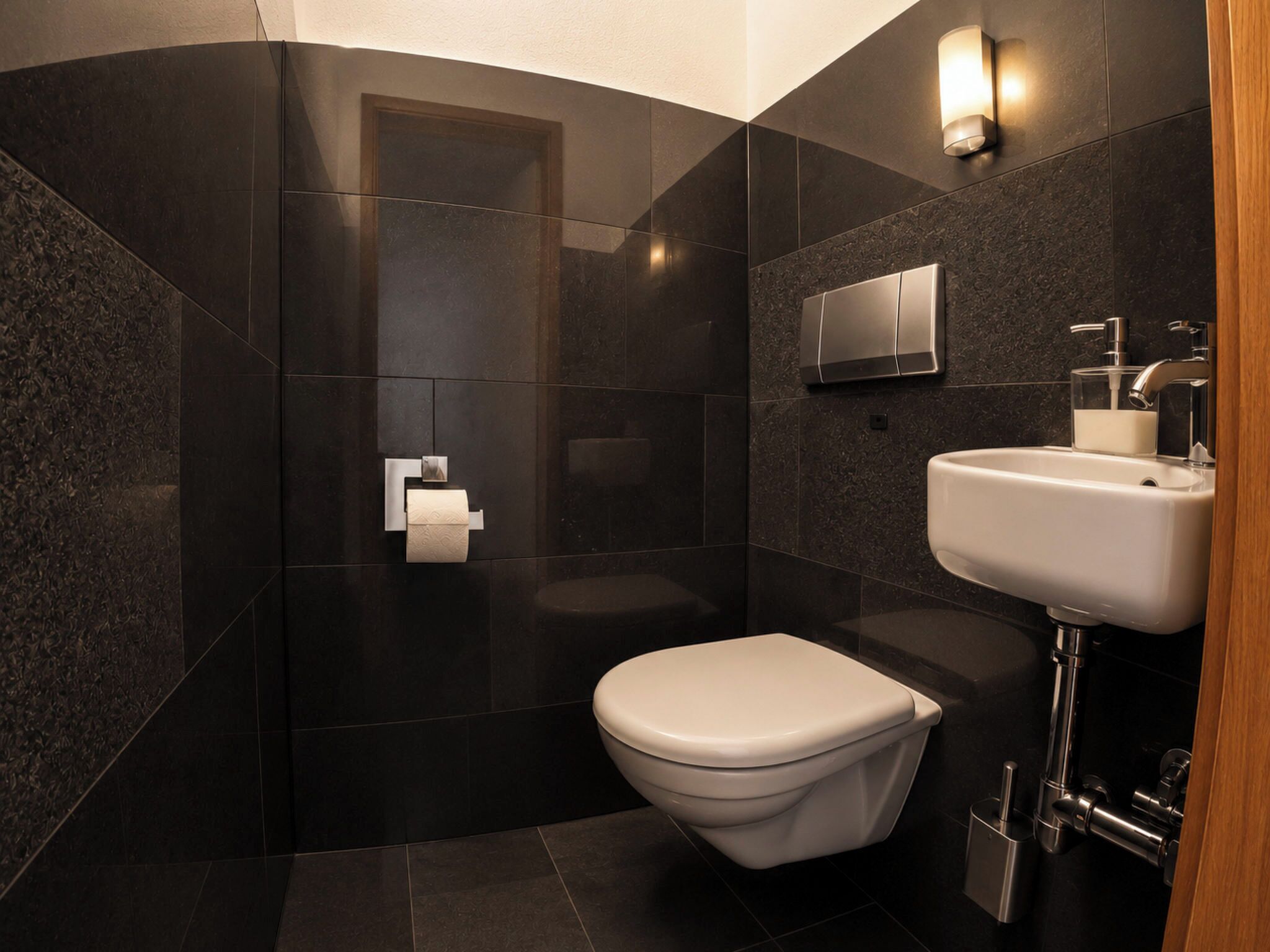 Une salle de bain moderne équipée de toilettes, d’un lavabo et d’un espace douche.