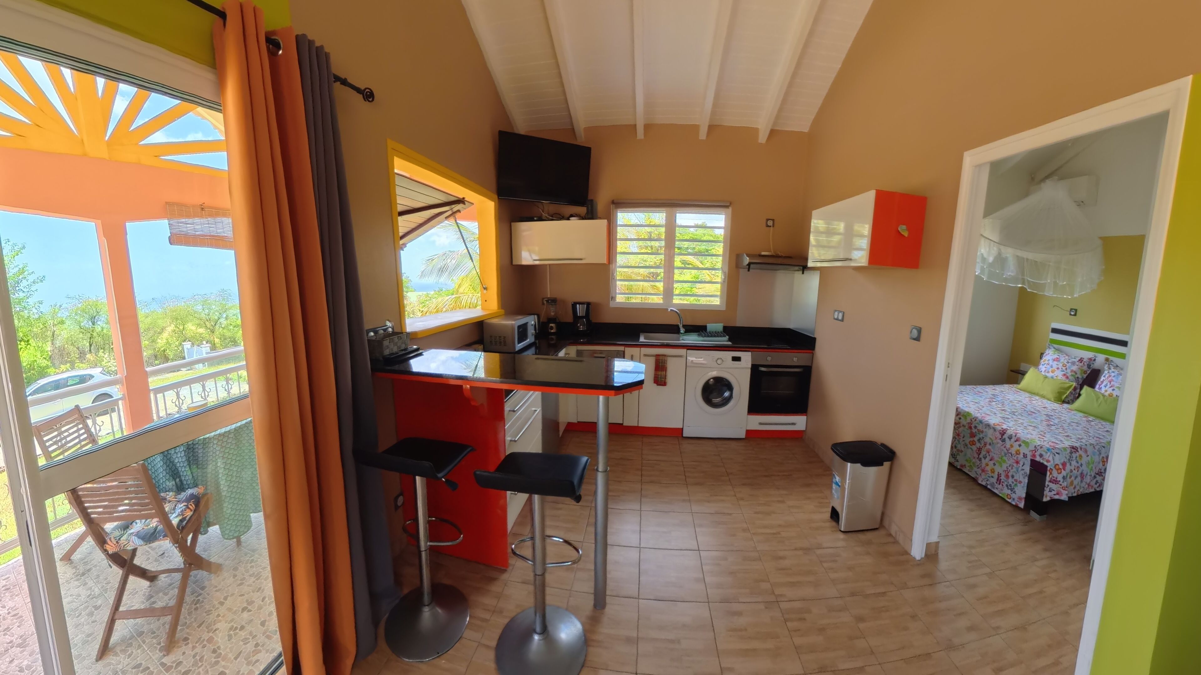 Una cocina compacta con lavadora, microondas y lavamanos.