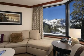 A hotel room with a sofa, a small table, a telephone, and a window with a mountain view. - Valley-View Suite in stunning Olympic Valley. Minutes away from Lake Tahoe and Truckee. (Olympic Valley)