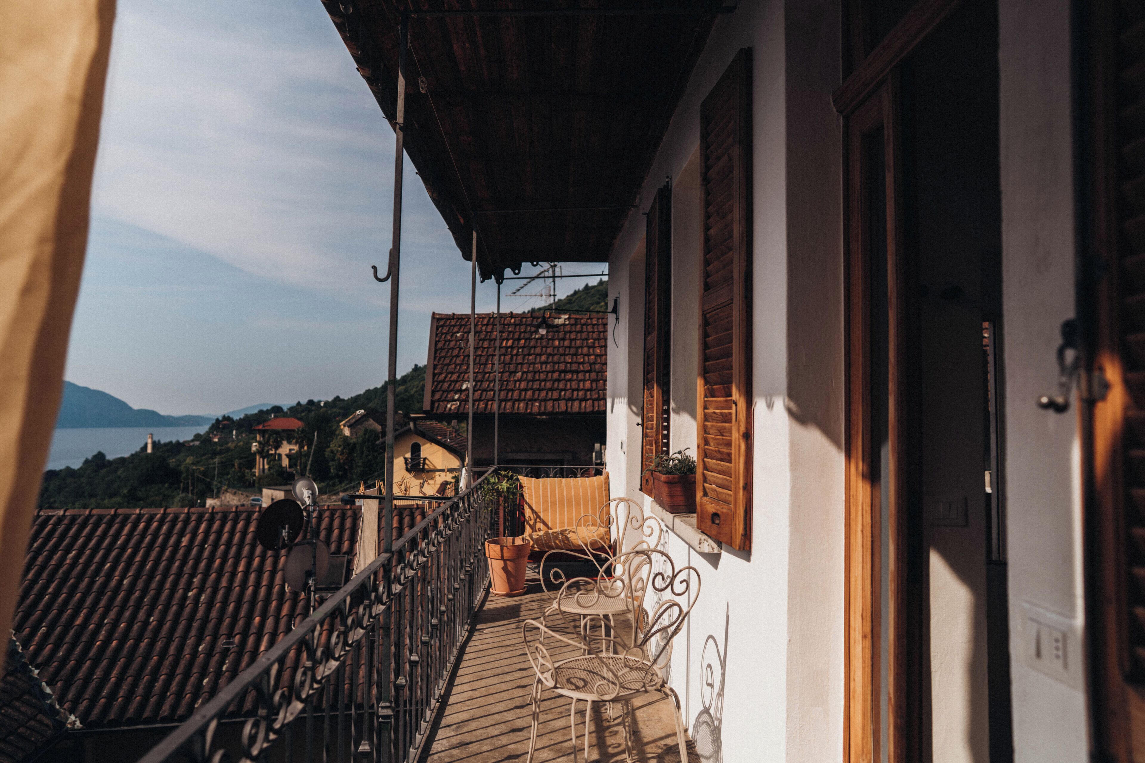 Un balcone con vista sul mare, un tavolo di legno e una sedia.