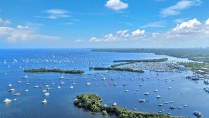 Marina com vários barcos atracados, rodeada por água e vegetação.