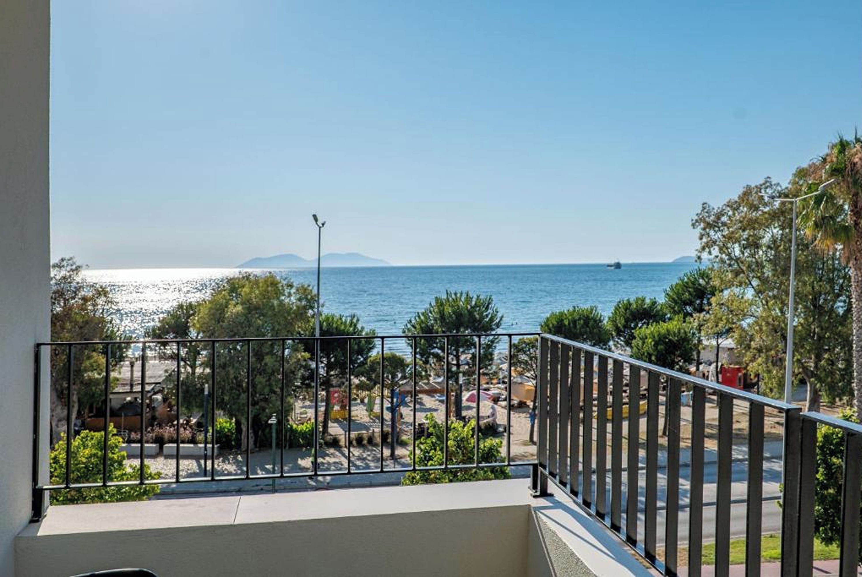 A balcony with a view of a beach and the sea.