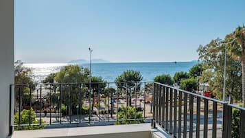 A balcony with a view of a beach and the sea.
