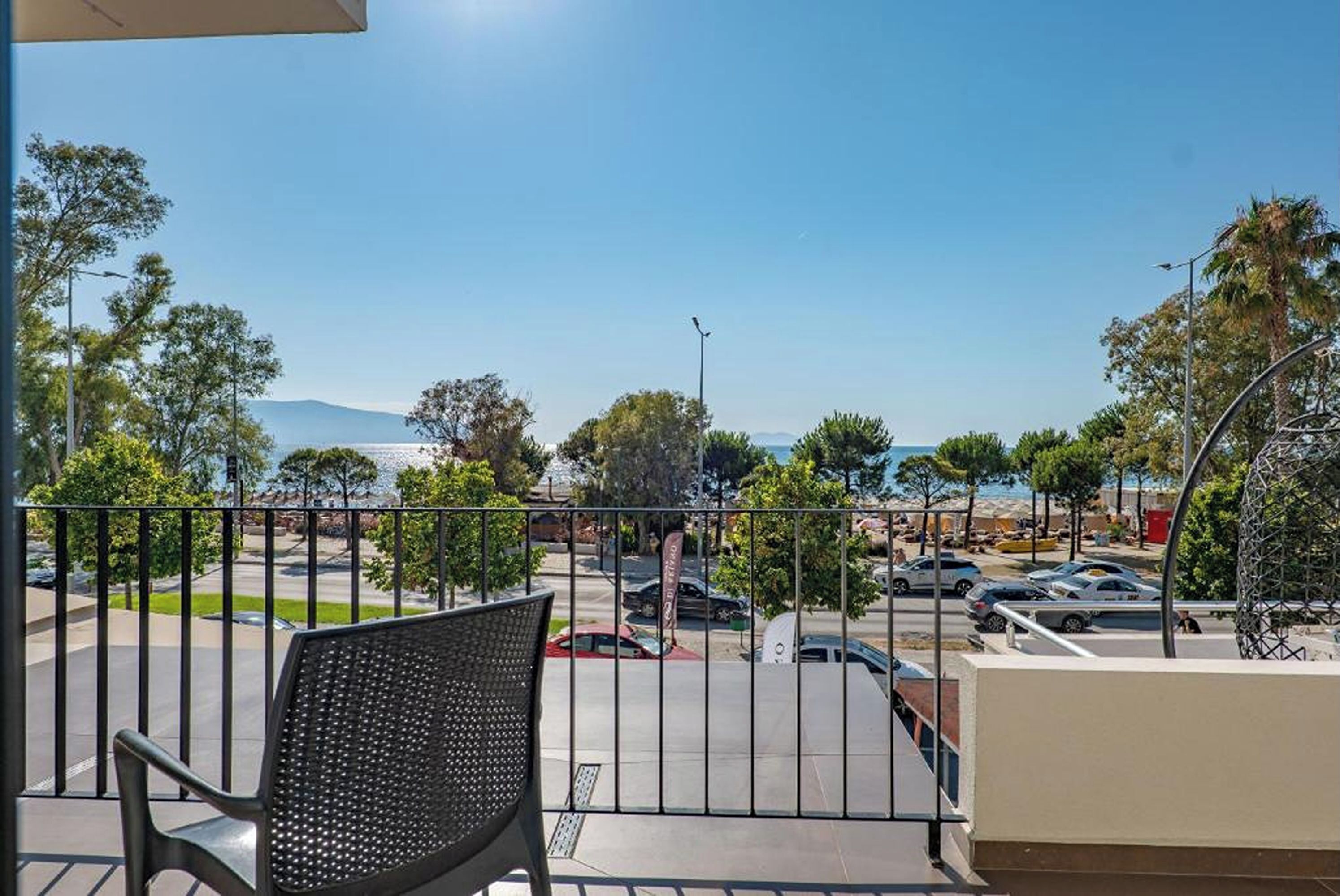 A balcony with a view of a parking lot and a distant mountain range.
