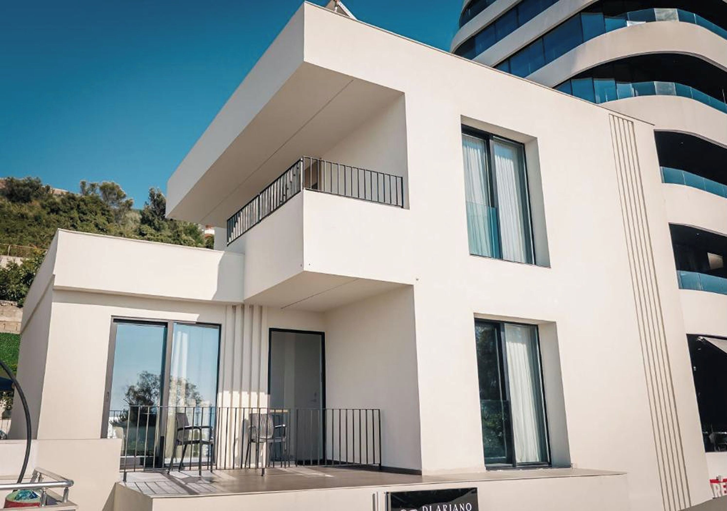 Un edificio moderno con balcones, ventanas amplias y un letrero que dice 'DILARIANO'.