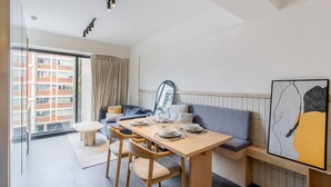 A modern hotel room with a dining area, a sofa, and a large window. - Myla - Loft in Condesa (Mexico City)