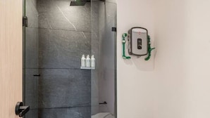 A bathroom with a shower, toilet, and a wall-mounted water heater. - Myla - Loft in Condesa (Mexico City)