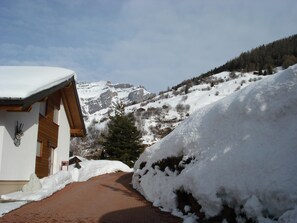 A snow-covered mountain path leading to a building with a wooden facade and a snow-covered roof. - Chalet Kristall # 6-bed apartment, Dusche, WC 6-bed apartment, Dusche, WC by Interhome (Albinen)