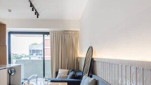 Ein modernes Hotelzimmer mit Essbereich, einer Couch und Blick auf die Stadt.