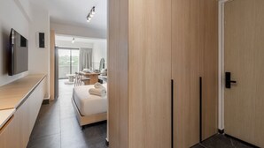 A modern hotel room with a bed, a desk, a flat-screen TV, and a view of the outdoors. - Myla - 1BR Loft Plus in Condesa with balcony (Mexico City)