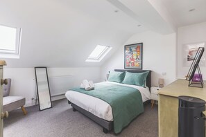 A bedroom with a bed, a radiator, a window, and a skylight. - Spacious 2BDR 2BA near Shepherds Bush Oasis (Greater London)