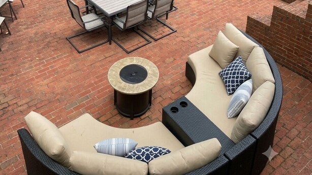 An outdoor patio with a brick floor, a round sofa, a dining table with chairs, and string lights. - Main House + Studio Cottage • 2 Acres (Greer)