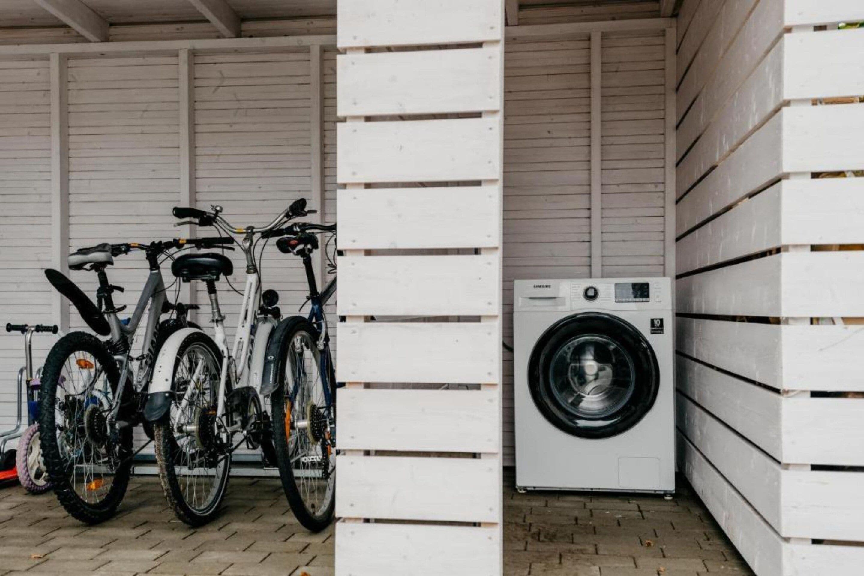 A garage with bicycles and a washing machine.