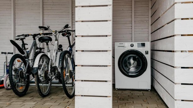 Un garage contenant deux vélos et un lave-linge.