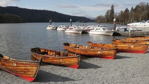 A lakeside dock with several wooden boats and a few motorboats. - Fox Red Retreat (Windermere)