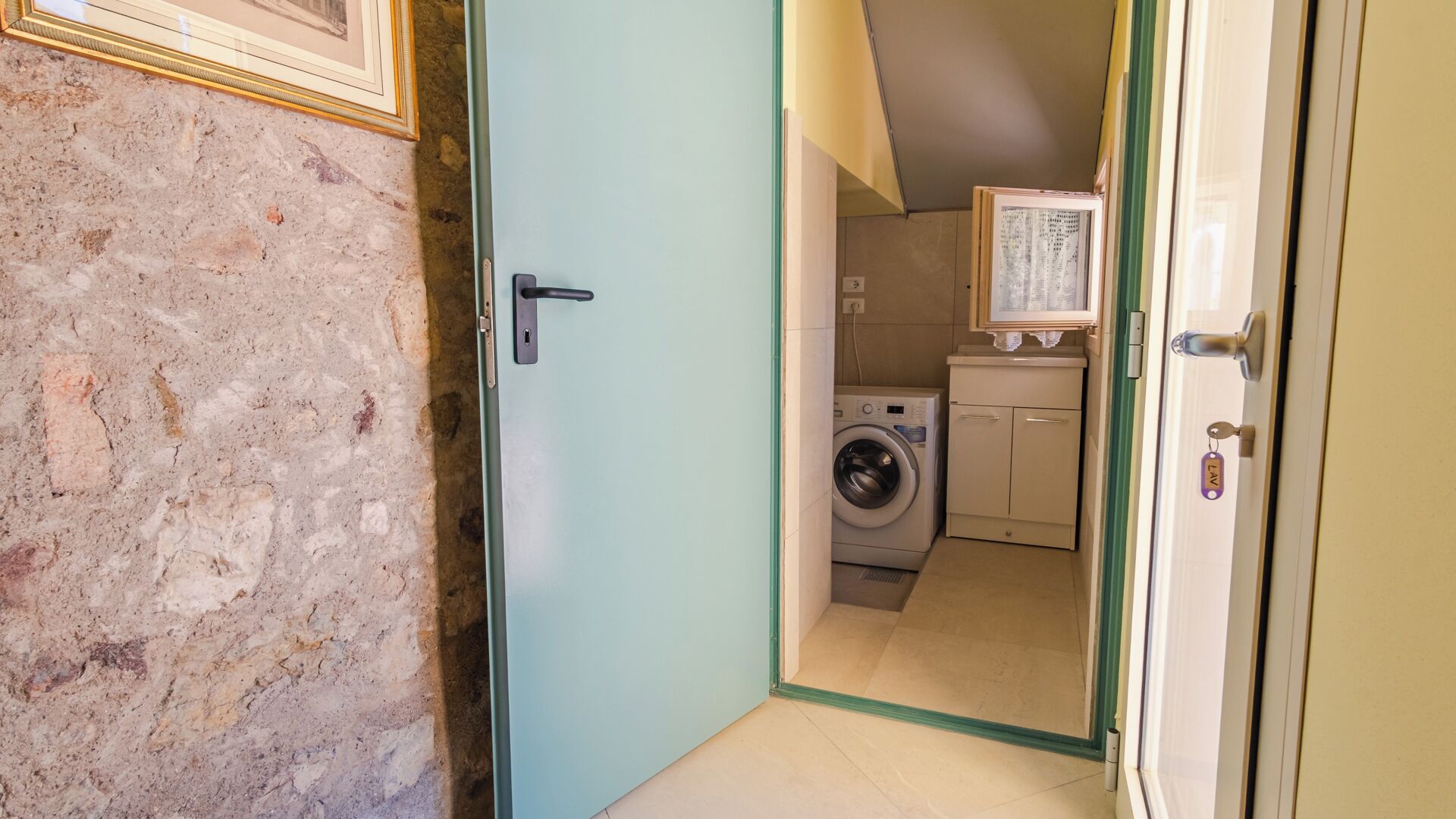 Une buanderie équipée d’un lave-linge, d’un sèche-linge et d’un meuble de rangement.
