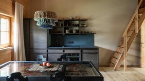 A dining area with a glass table, chairs, a hanging light fixture, and a kitchen in the background. - Apartment 'Masherbrum - Juval Oberortlhof' with Mountain View and Wi-Fi (Juvale)