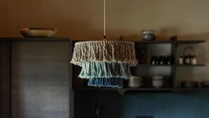 A modern kitchen with a wooden dining table and chairs, a hanging light fixture, and a kitchen counter with various items. - Apartment 'Masherbrum - Juval Oberortlhof' with Mountain View and Wi-Fi (Juvale)