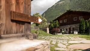 A rustic wooden building with a stone pathway leading to a stone entrance. - Apartment 'Masherbrum - Juval Oberortlhof' with Mountain View and Wi-Fi (Juvale)