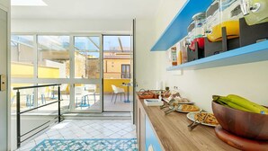 Una cocina moderna con encimera de madera, una cafetera y un cuenco de plátanos.
