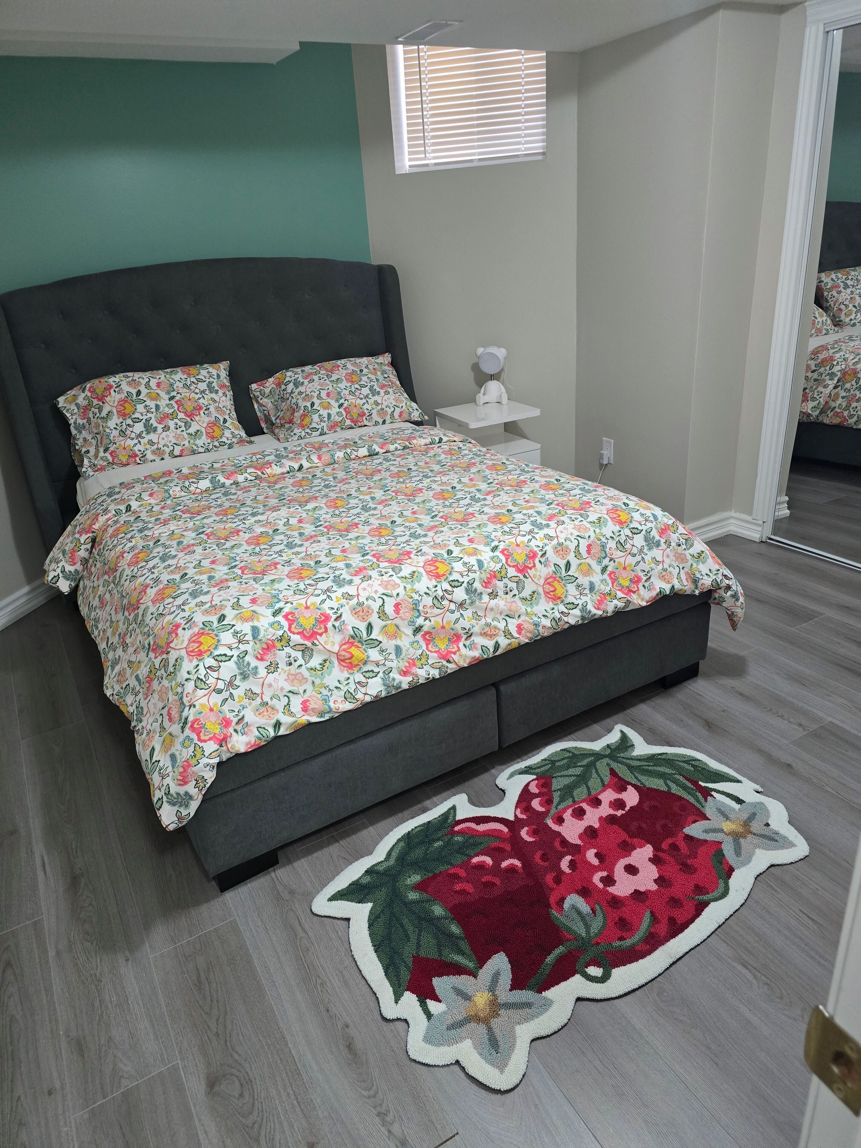 Un dormitorio con cama, mesita de noche y espejo.