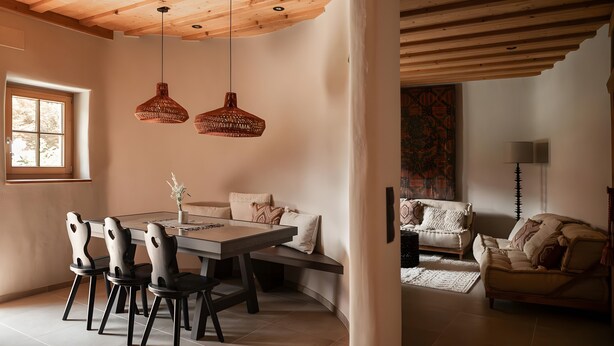 A dining area with a wooden table, chairs, and pendant lights. - Apartment 'Kailash - Juval Oberortlhof' with Mountain View and Wi-Fi (Juvale)