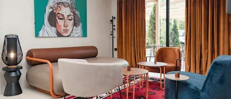 Ein modernes Wohnzimmer mit einer Couch, einem Sessel und einem kleinen Tisch.