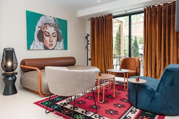A modern living room with a sofa, armchair, and a small table.