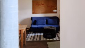 A room with a blue sofa, a wooden table, a patterned rug, and a painting on the wall. - Apartment 'Cho Oyu - Juval Oberortlhof' with Mountain View and Wi-Fi (Juvale)