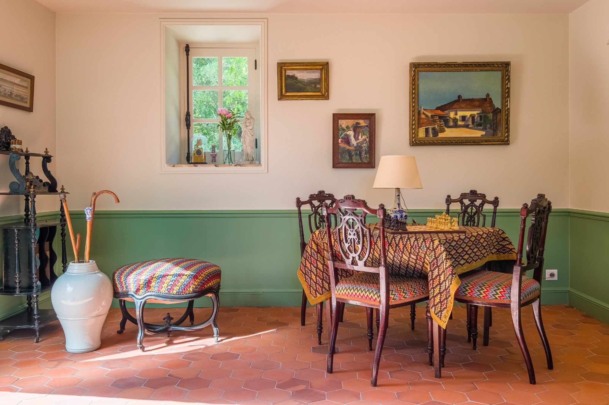 A dining area with a table set for four, surrounded by wooden chairs.