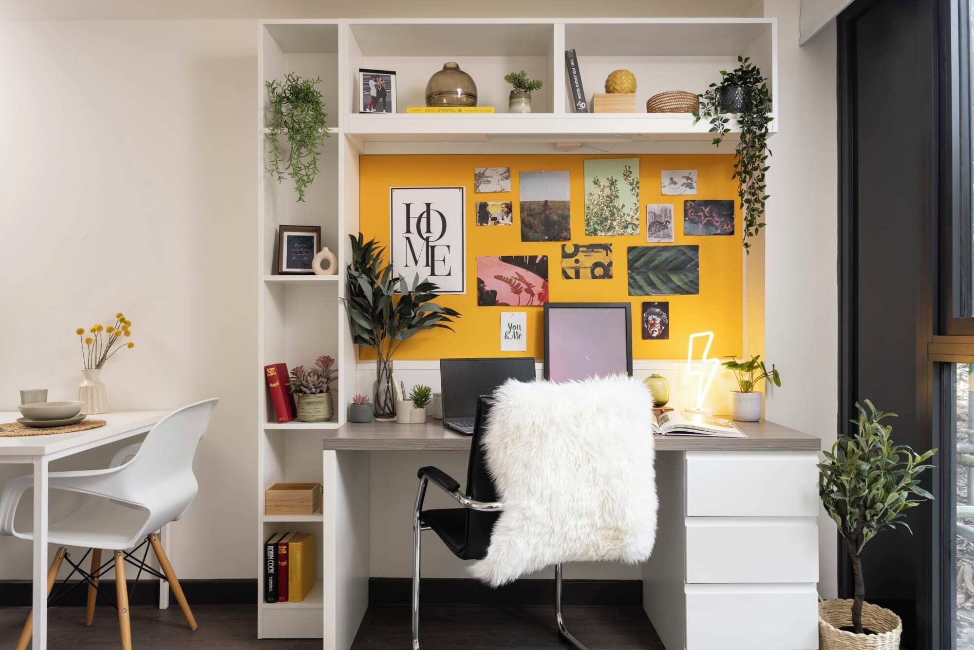 Un espace de travail moderne comprenant un bureau, une chaise, des étagères et divers objets décoratifs.
