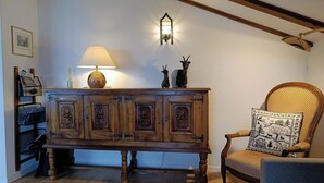 A wooden cabinet with decorative carvings, a lamp, and a chair with a patterned cushion. - Frégate 44 # 4-bed apartment, Dusche, WC 4-Bettwohnung, Dusche, WC by Interhome (Leukerbad)