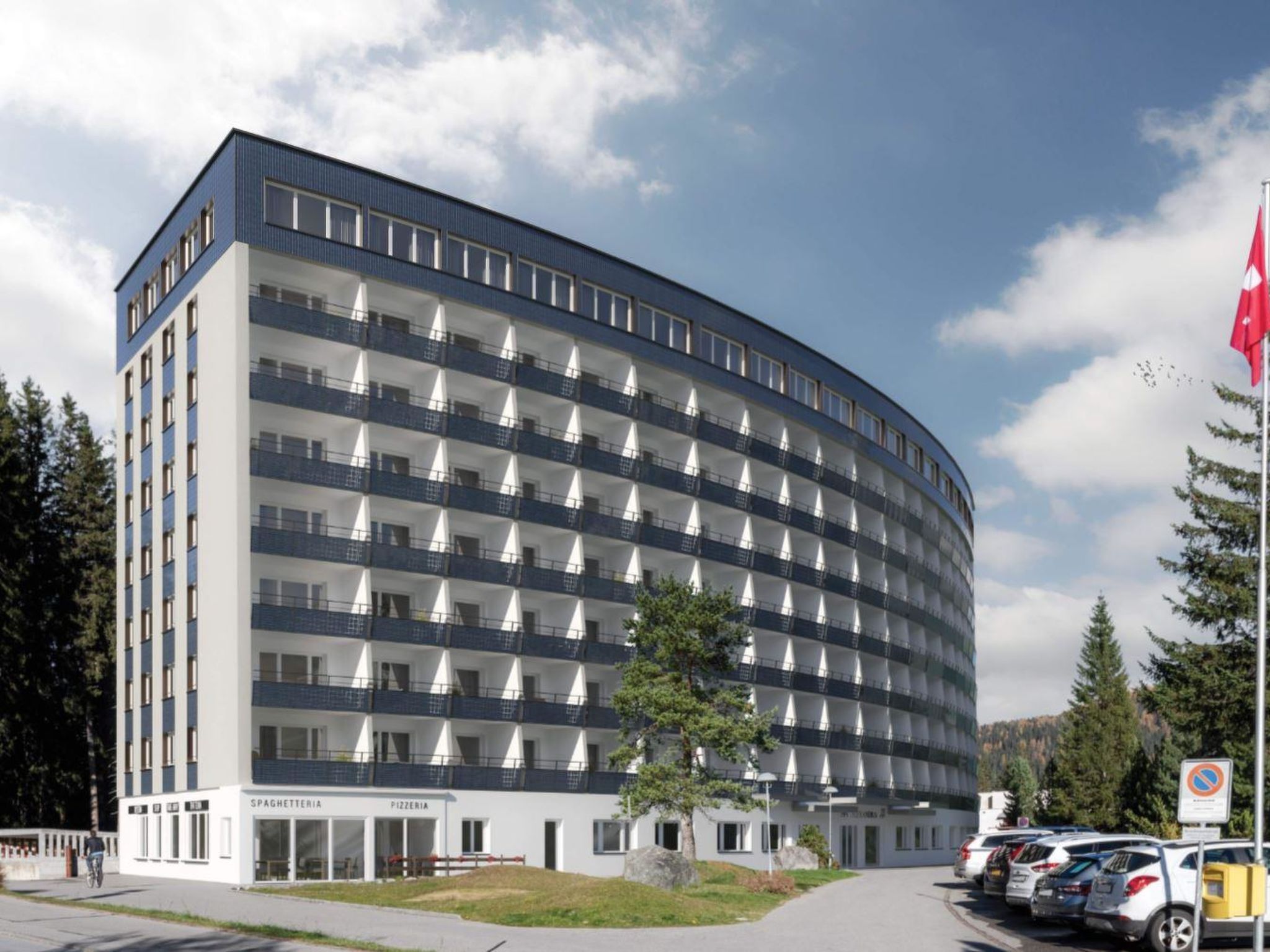 Un hôtel à plusieurs étages, doté d’une façade incurvée, de balcons et d’un drapeau.