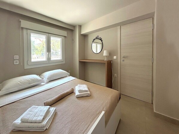 A hotel room with a bed, a window, a mirror, and a wardrobe. - Casa Verde Minimal Cozy Stay (Elliniko-Argyroupoli)