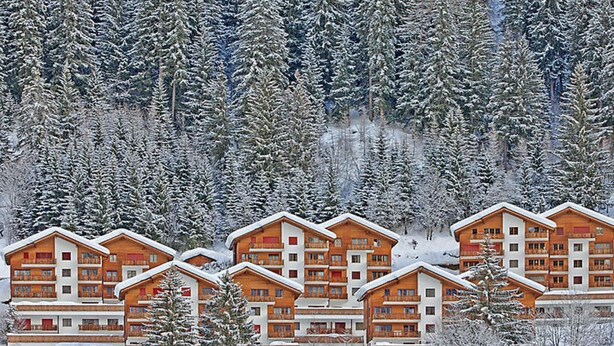 A cluster of wooden multi-story buildings with balconies, surrounded by snow-covered trees. - Les Naturelles B 106 # 5-bed apartment, Dusche und Bad, WC by Interhome (Leukerbad)
