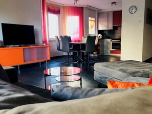 A modern living room with a sofa, a glass coffee table, and a TV on a stand. - Edelweiss D 11 # 4-bed apartment, Dusche, WC 4-Bettwohnung, Dusche, WC by Interhome (Leukerbad)