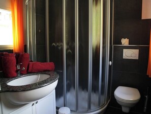 Ein Badezimmer mit Dusche, Waschbecken und Toilette.